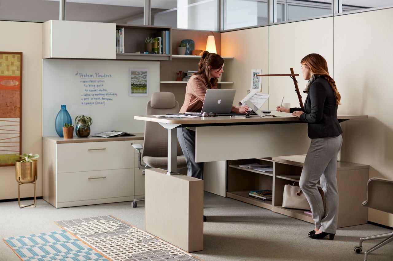 Two women working at a Haworth Masters Series Height Adjustable Desk