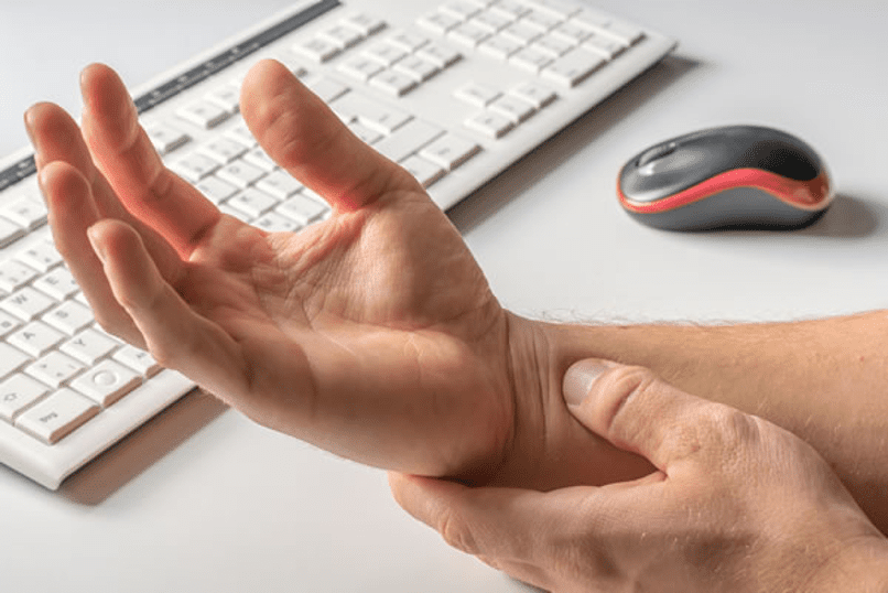 Man grabbing and stretching his wrist because of carpal tunnel pain
